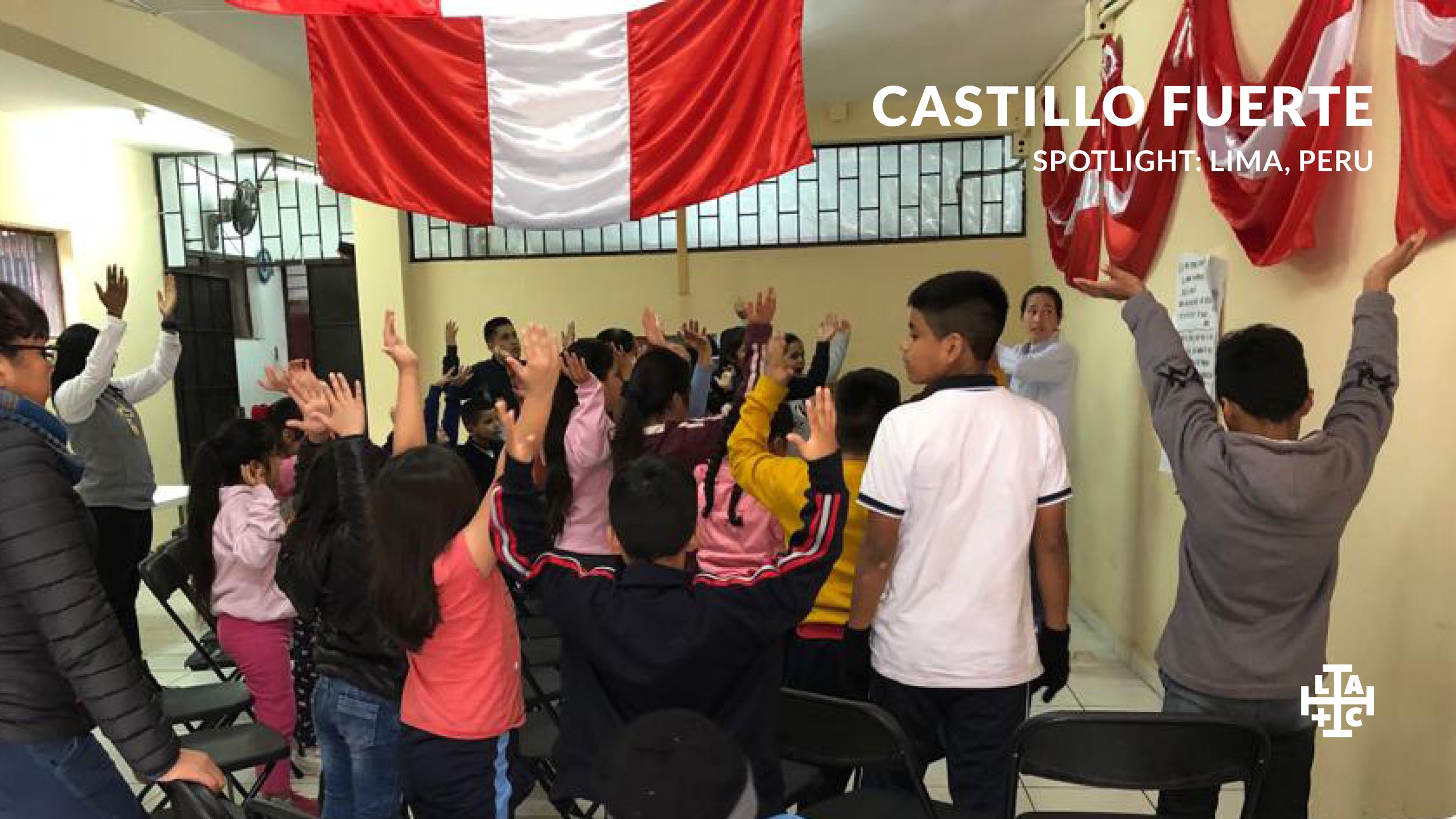 Grupo de niños y jóvenes en una iglesia, algunos levantando la mano, celebrando o participando en un evento, con una bandera de Perú colgada en la pared.