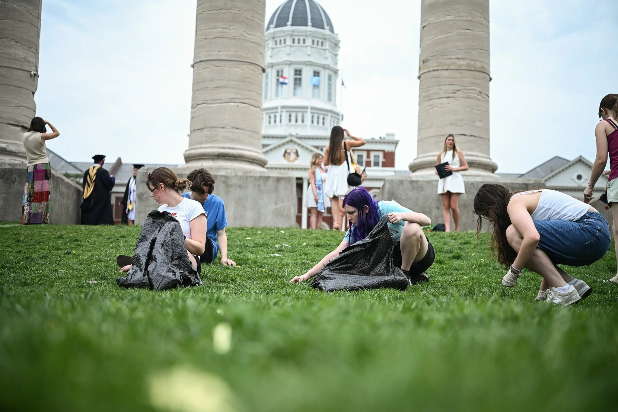 Students picking up leftover confetti from all the graduation pictures on April 26 in Columbia, Mo. Leah Chadwell, 22, the service co-chair of Beta Chi Omicron shares one of the major callings of the organization is the “call to serve,” which include