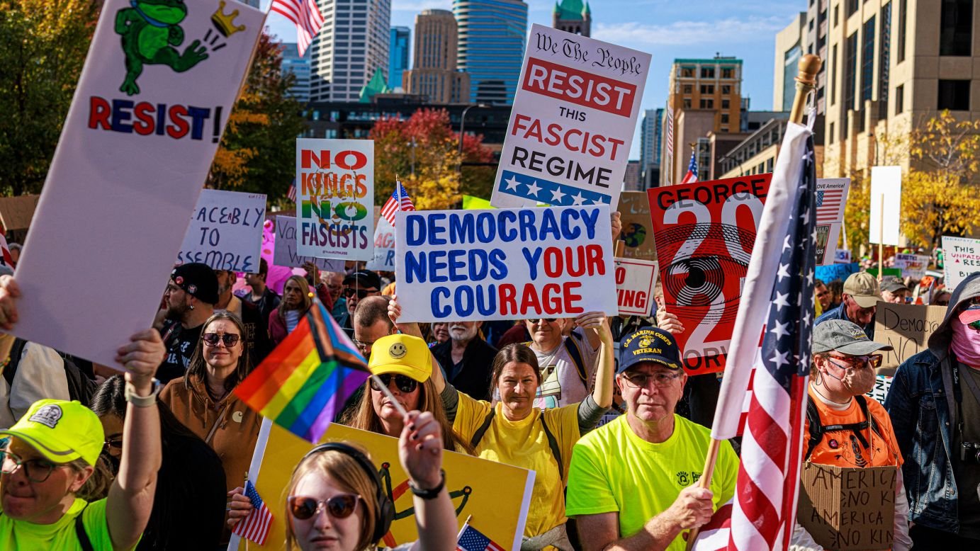 National protest with large crowd holding signs supporting democracy, civil rights, and nationwide political activism in the United States