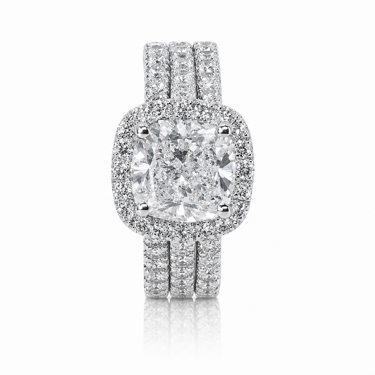 Diamond engagement ring with a large central cushion-cut diamond surrounded by smaller diamonds and a double band encrusted with diamonds.