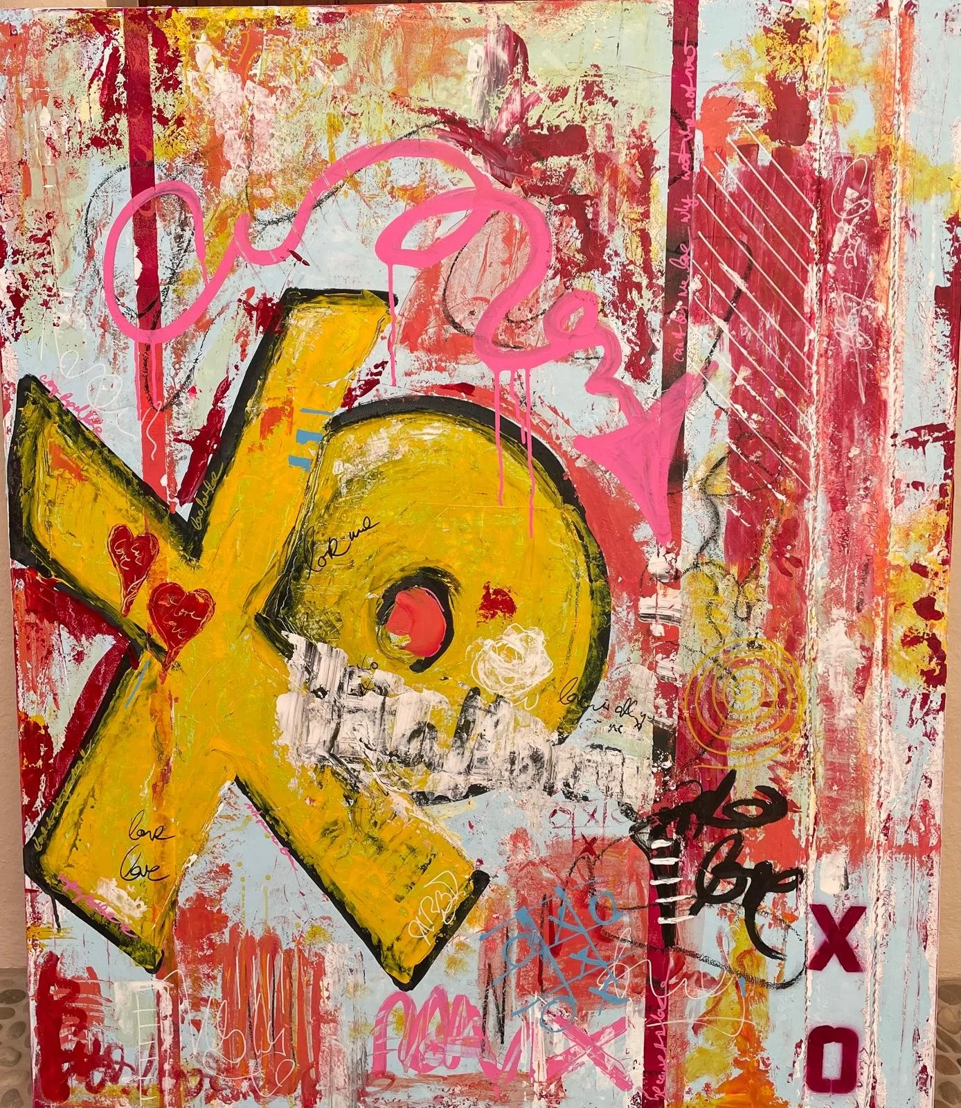Abstract graffiti-style painting with a large yellow star, pink flamingo outline, red hearts, and various scribbles and layered paint. Includes words like 'love' and 'x' in different colors.