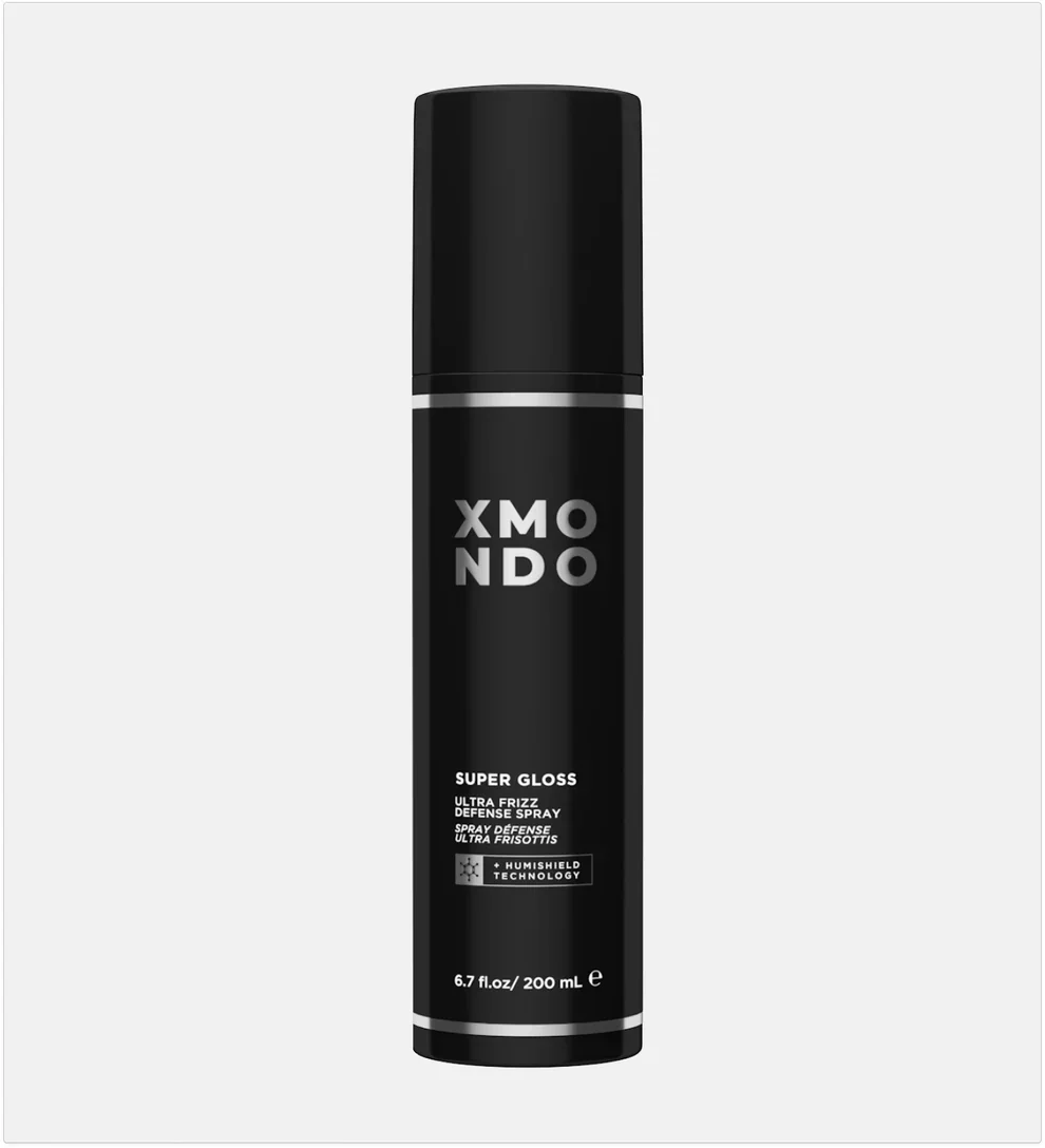 A black can of XMONDO Super Gloss Ultra Frizz Defense Spray with a black cap and silver accents, labeled with technology details and size of 6.7 fluid ounces.