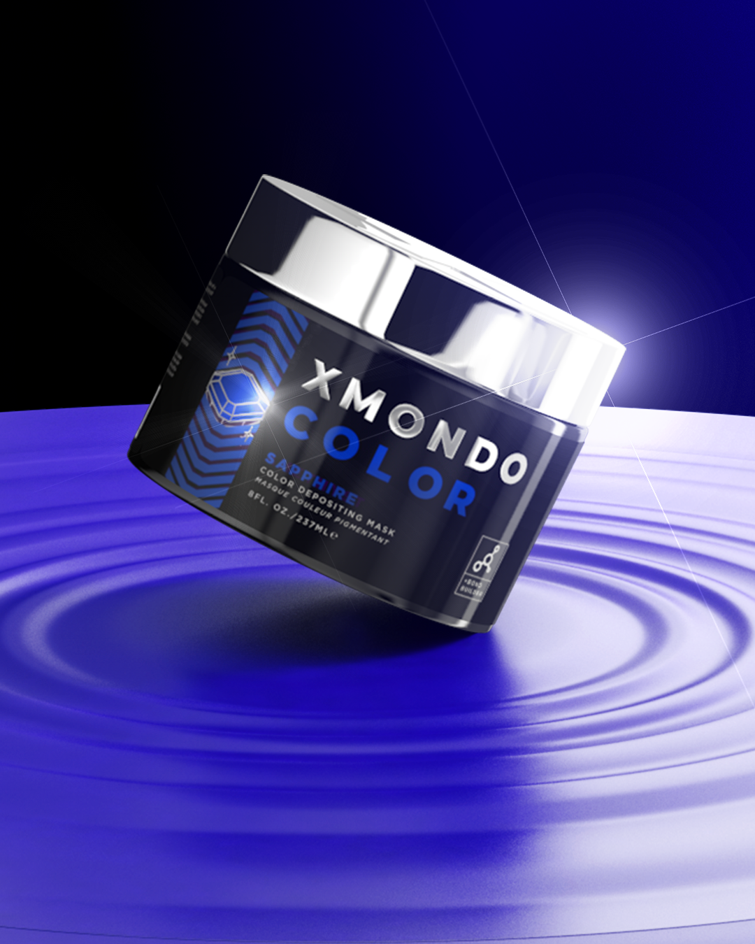 A jar of X Monde Color Sapphire Depositing Mask with a silver lid, set against a dark background with a blue, wavy surface, illuminated by a bright light.