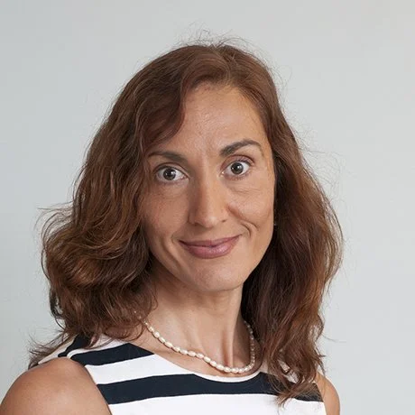 Ana-Maria Vranceanu, PhD wearing navy and white striped sleeveless top and pearls