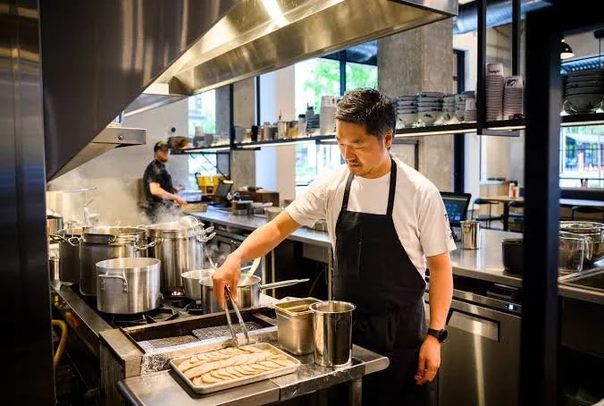 A chef cooking on a stovetop in a modern kitchen.
