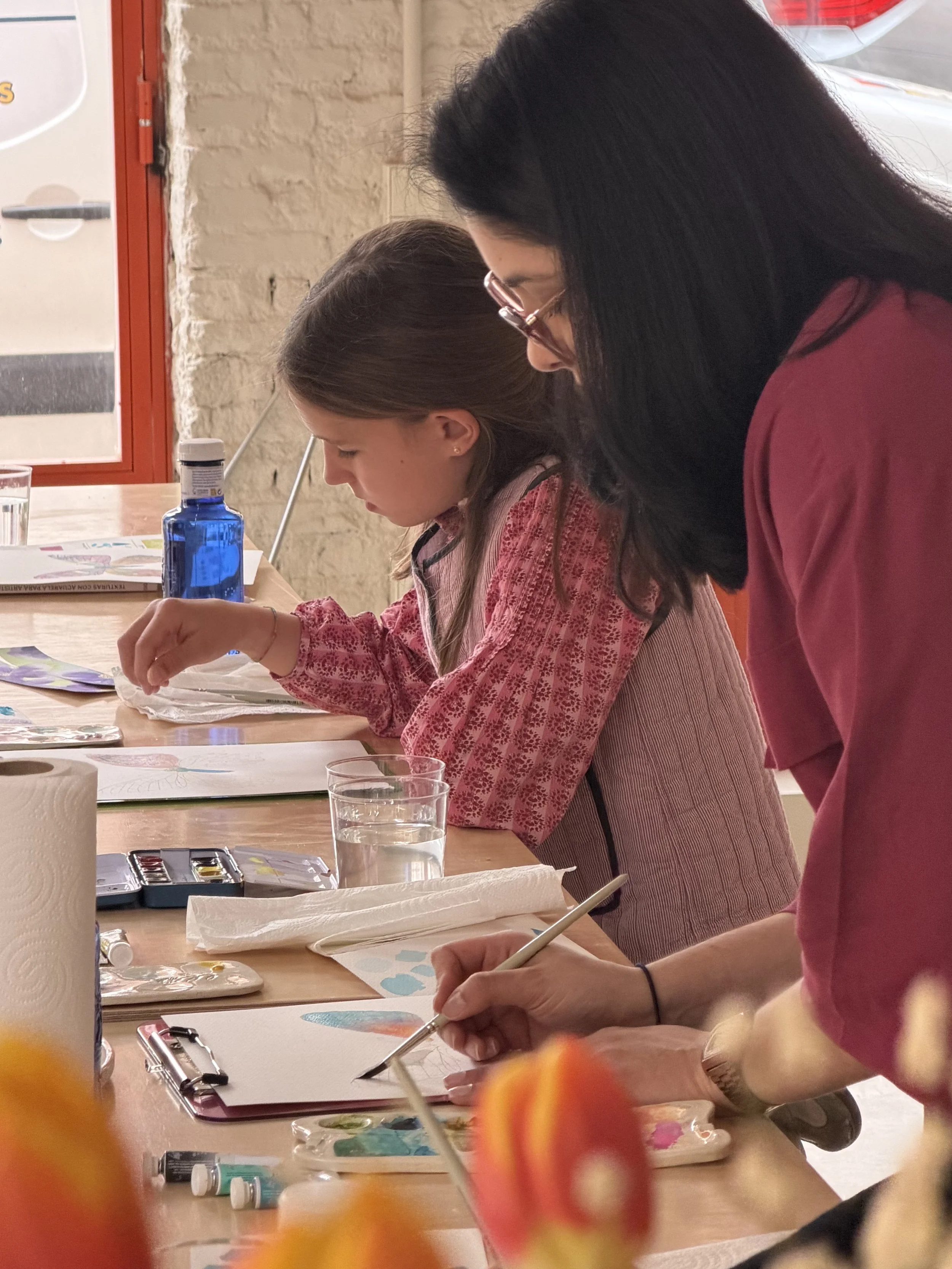 Carlissima dando talleres de acuarela en madrid con una mesa y materiales artísticos.