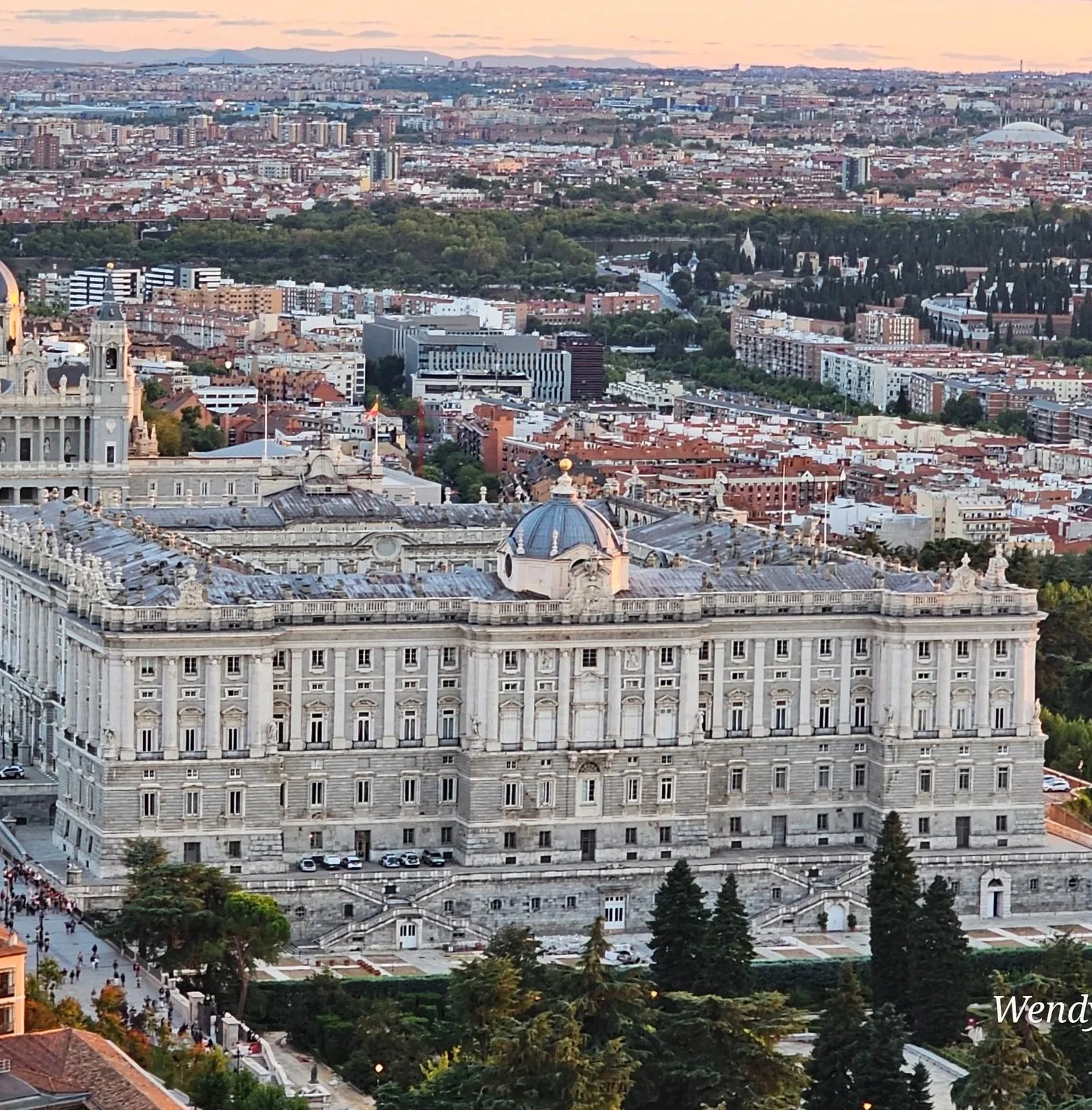 anoramic aerial cityscape view of Madrid showing historic red tile rooftops and the Royal Palace dome.