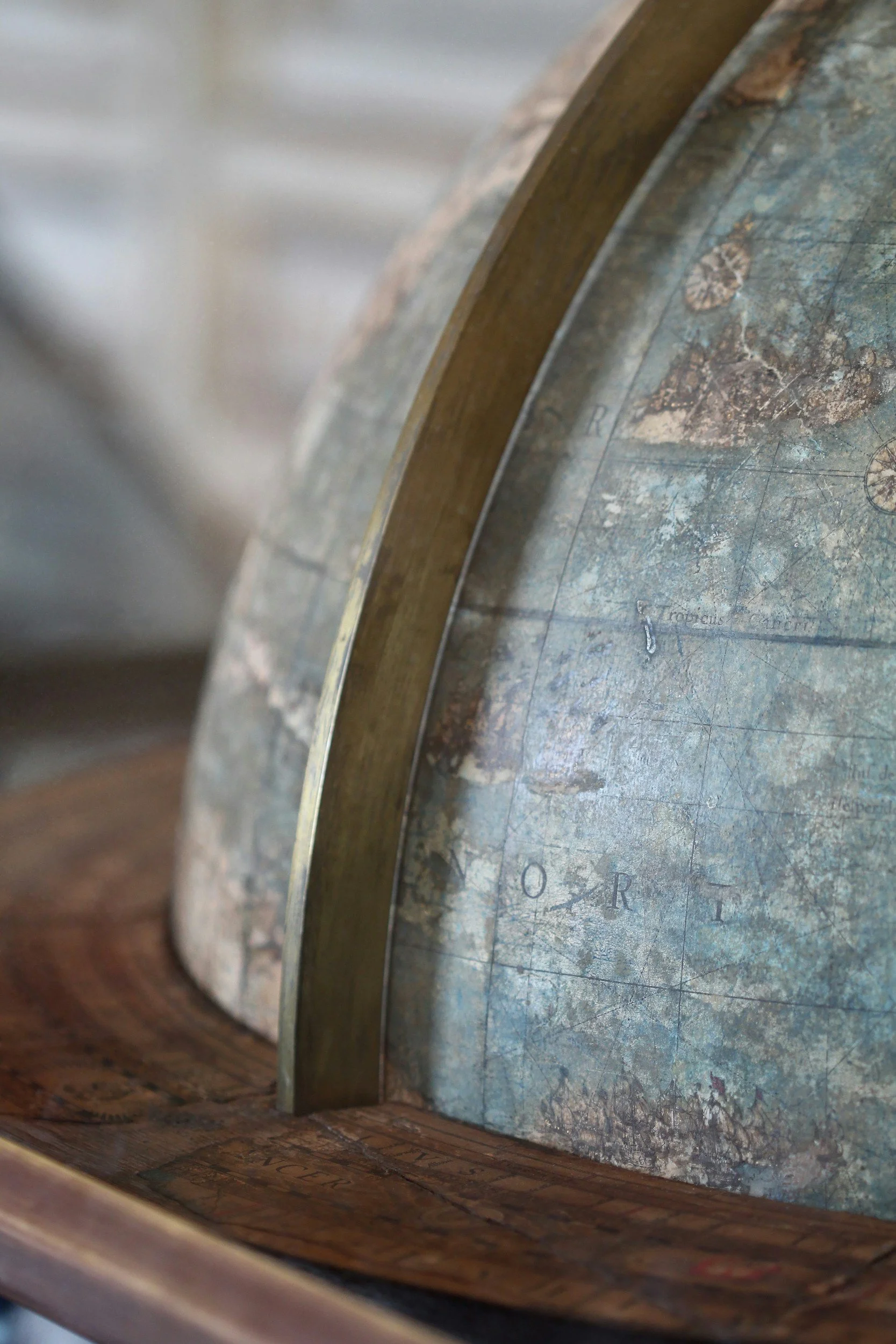 Close-up of an old, worn globe showing parts of Europe and the Atlantic Ocean with visible map details and labels.