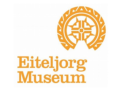 Eiteljorg Museum logo in orange with a circular design and cross-like symbol inside.