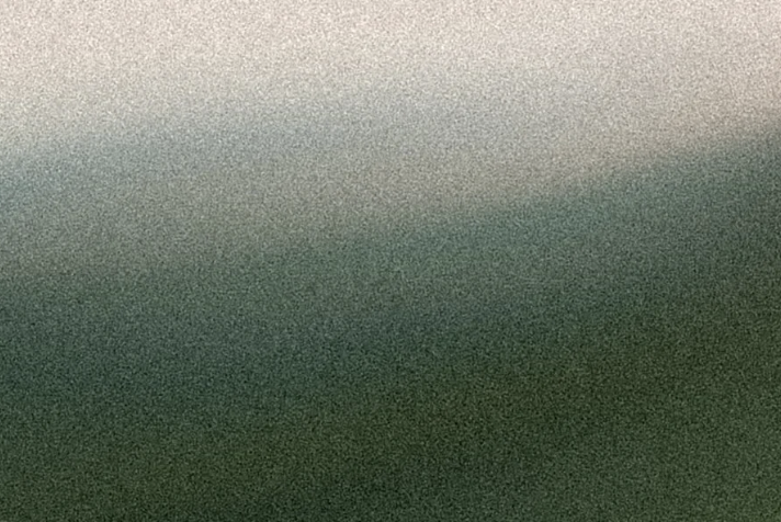 A blurry, grainy image with a gradient of green and gray colors.