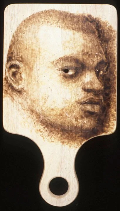 Untitled (mask), 1996, wood burning on cutting board