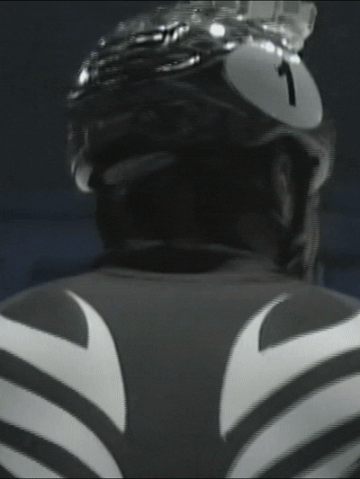 A person wearing a black helmet and a black and white striped cycling jersey.