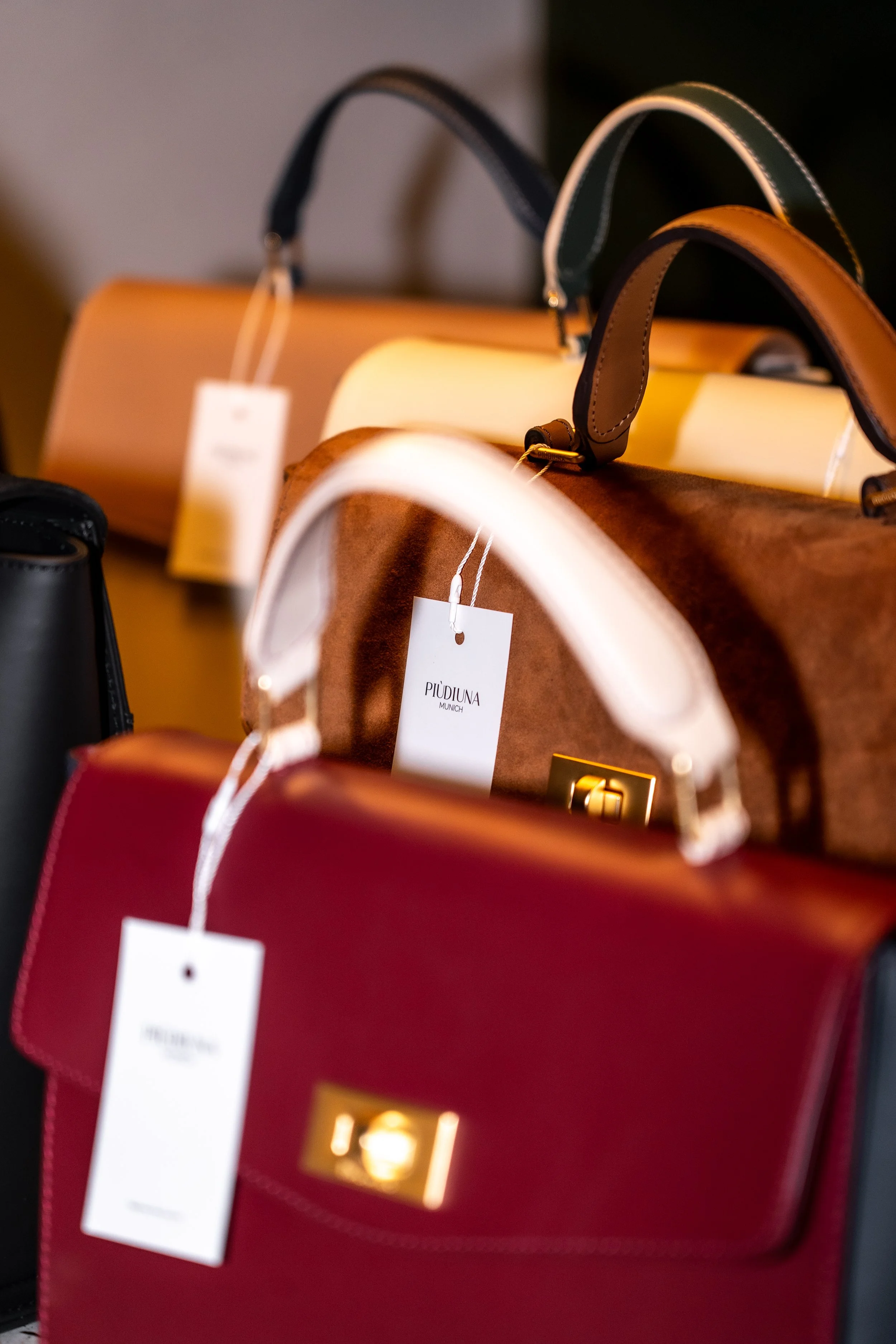 Verschiedene Handtaschen in verschiedenen Farben und Materialien, auf einer Verkaufsdisplay-Haftung im Geschäft.
