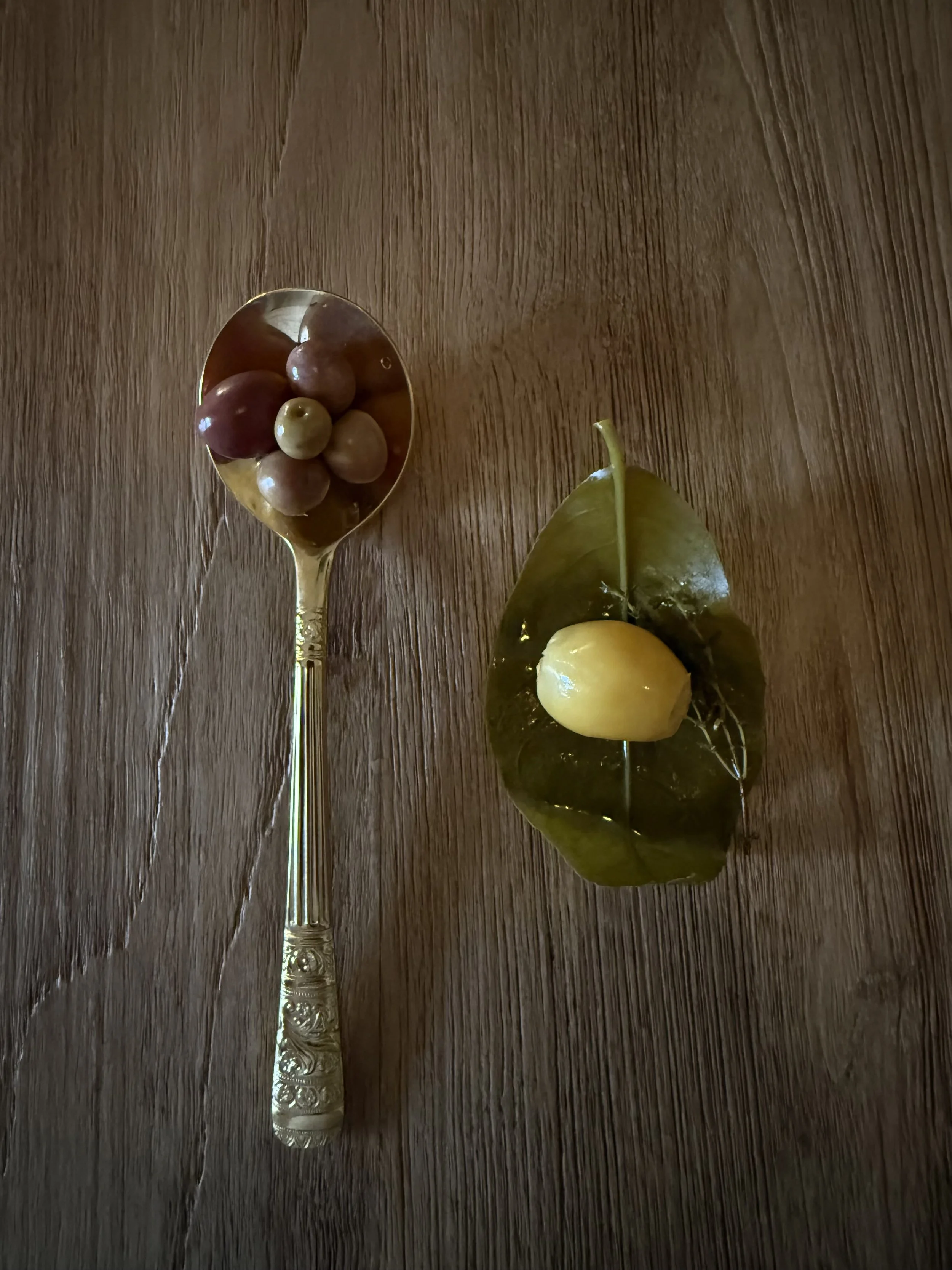 Olive oil pairing with red grapes and a local Mallorcan plum served on a wooden table at Olea Club, Palma de Mallorca.