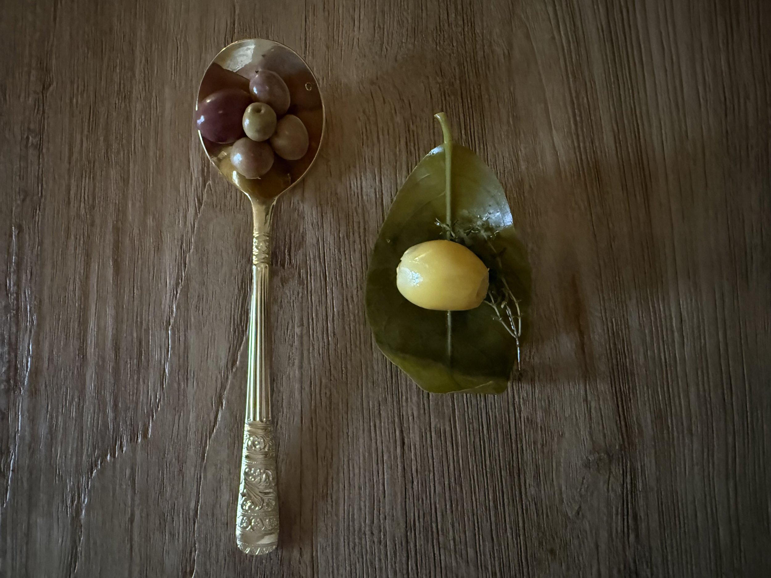 Olive oil pairing with red grapes and a local Mallorcan plum served on a wooden table at Olea Club, Palma de Mallorca.
