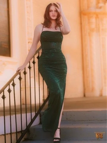 Photographer, for hire, Oceanside, Carlsbad, San Diego, Orange County, Fashion, Portraits, Moments, Lifestyle, Events, BrA woman in a strapless, dark green evening gown standing on a staircase with a black railing inside a well-lit, elegant building.