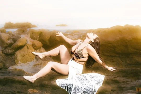 Photographer, for hire, Oceanside, Carlsbad, San Diego, Orange County, Fashion, Portraits, Moments, Lifestyle, Events, Branding.Woman in a bikini sitting on rocks near water, posing with her head back and eyes closed