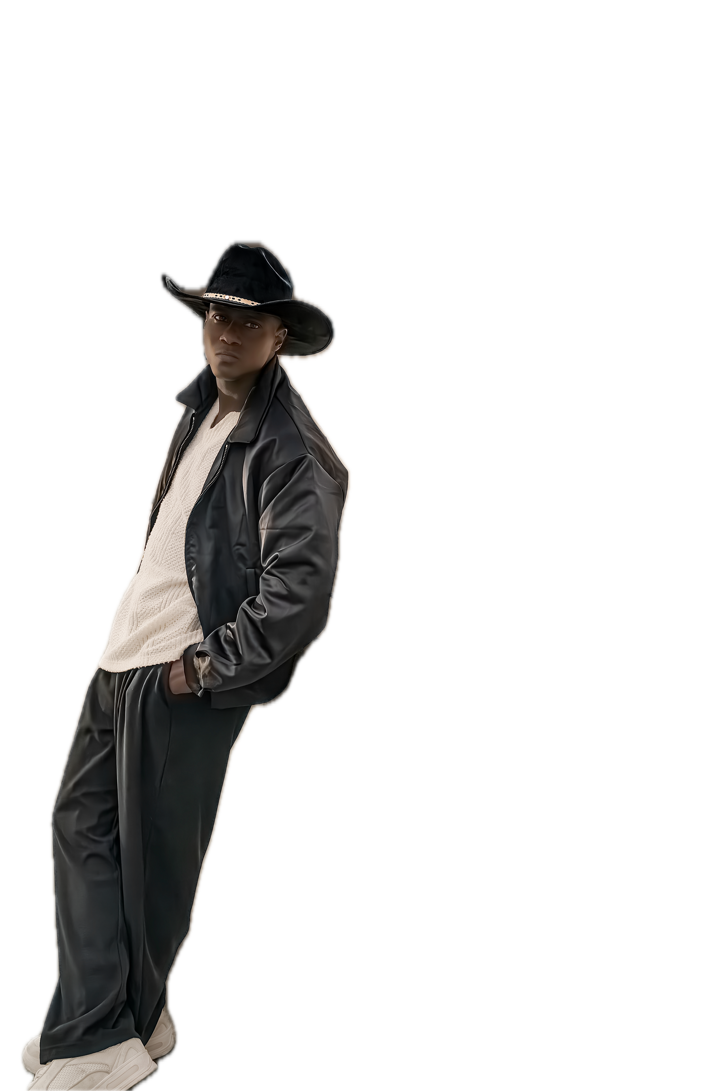 A young man wearing a black cowboy hat, black leather jacket, cream sweater, black pants, and white sneakers. He is standing with hands in pockets against a black background with colored horizontal streaks.