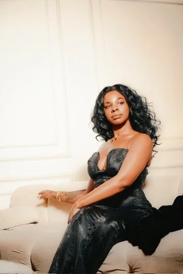Photographer, for hire, Oceanside, Carlsbad, San Diego, Orange County, Fashion, Portraits, Moments, Lifestyle, Events, Branding.Woman in a strapless black dress sitting on a beige couch in a room with white walls.