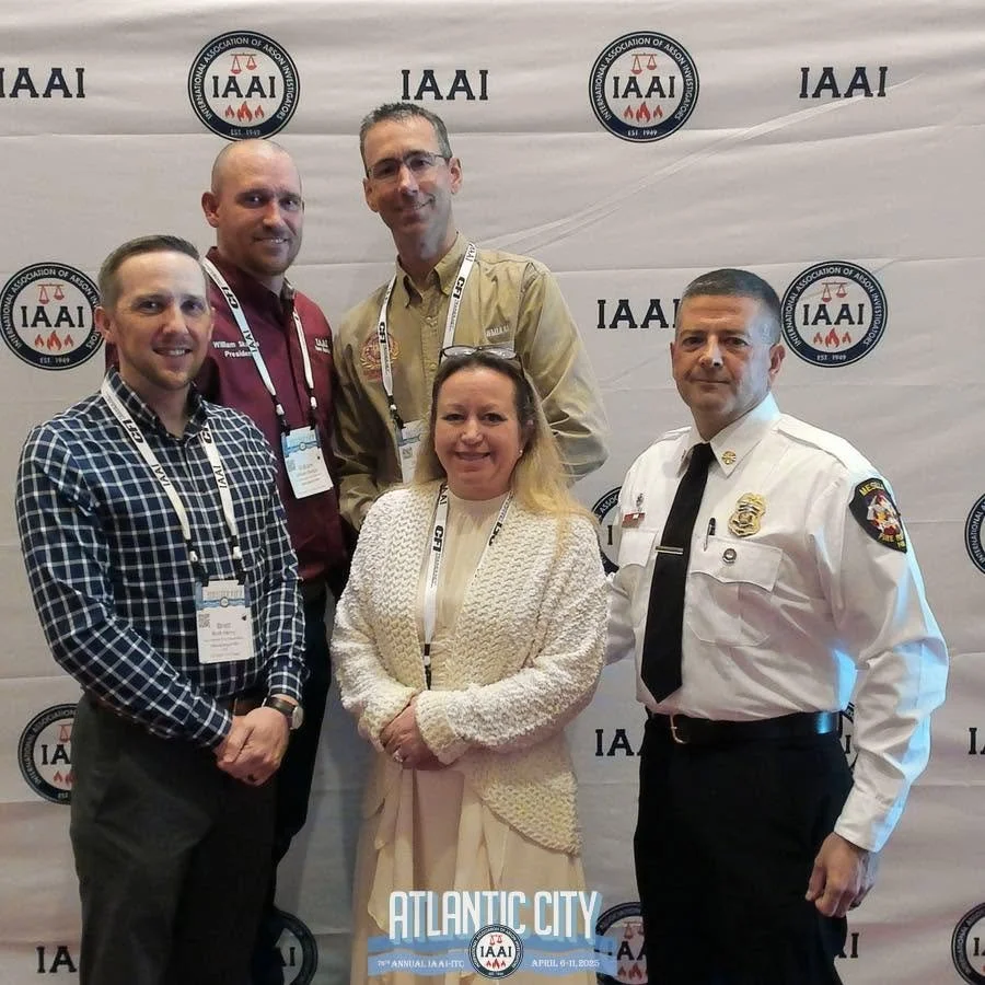 Group of six people posing in front of a banner with IAAI logos at the Atlantic City conference, April 8-11, 2023.
