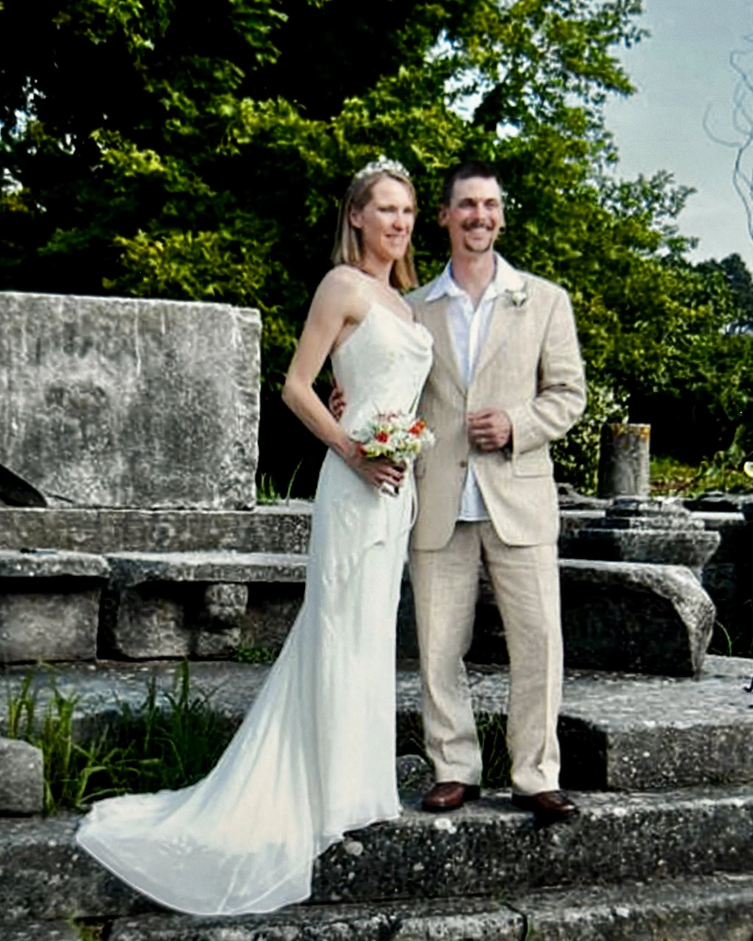 Couple standing on the old town ruins in Thassos having just got married in an outdoor ceremony.