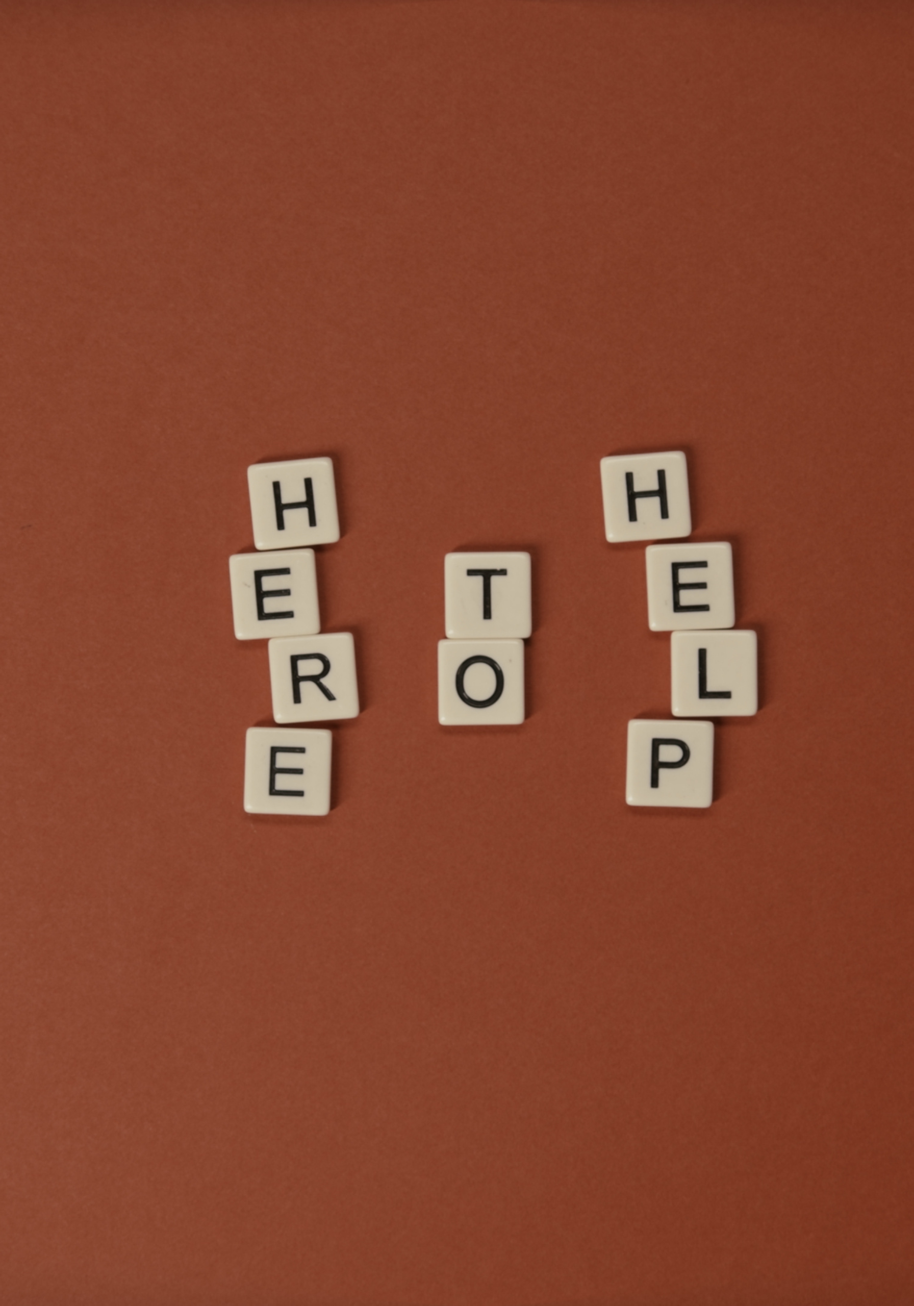 Scrabble tiles spelling out 'HELPER' and 'TOOL' on a red background.