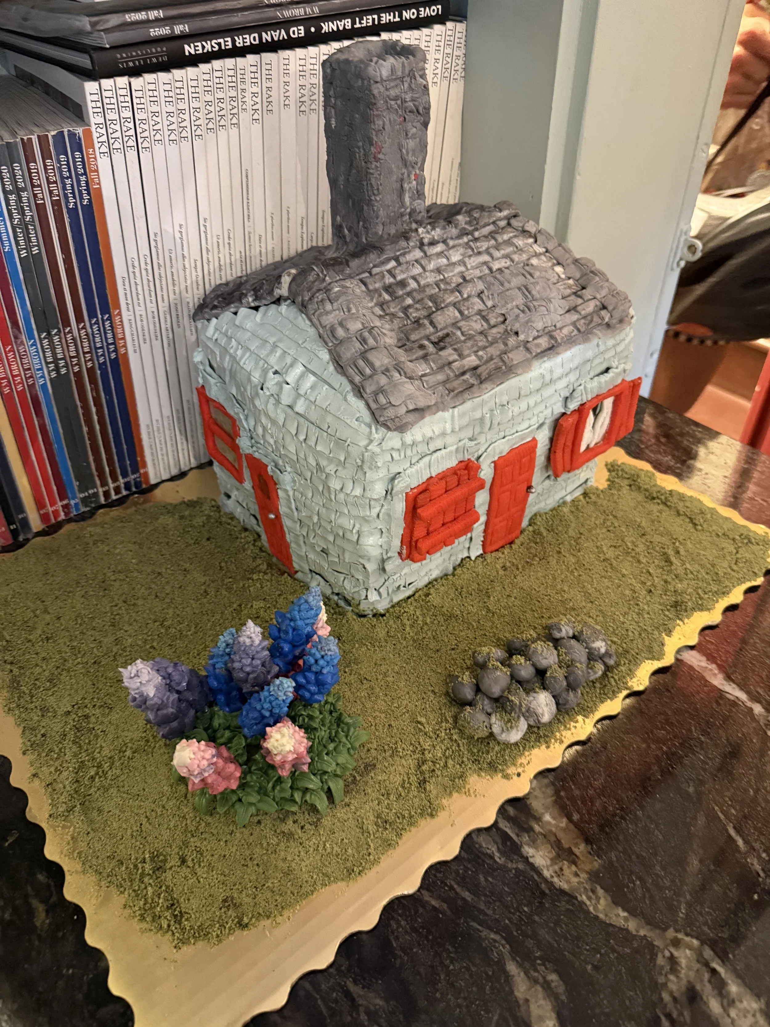 Blue House: a sculptural blueberry lemon cake made by artist and baker, Lucy Bennett. 

Lucy Bennett is a mother and baker based in Brooklyn. She draws on her background in screenwriting to inform her luxury cake-making business @cake_dump, building 