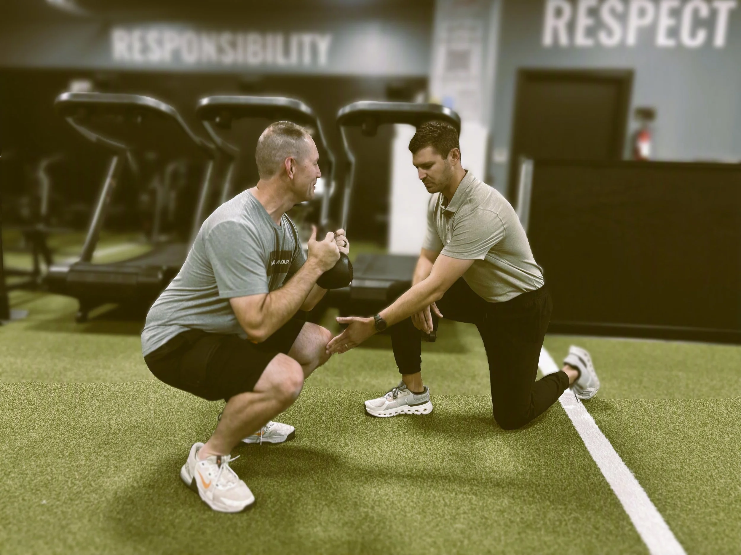 Best Physical therapist in Wichita coaching an adult through a kettlebell squat to improve mobility, strength, and golf performance at a premium one‑on‑one clinic in east Wichita
