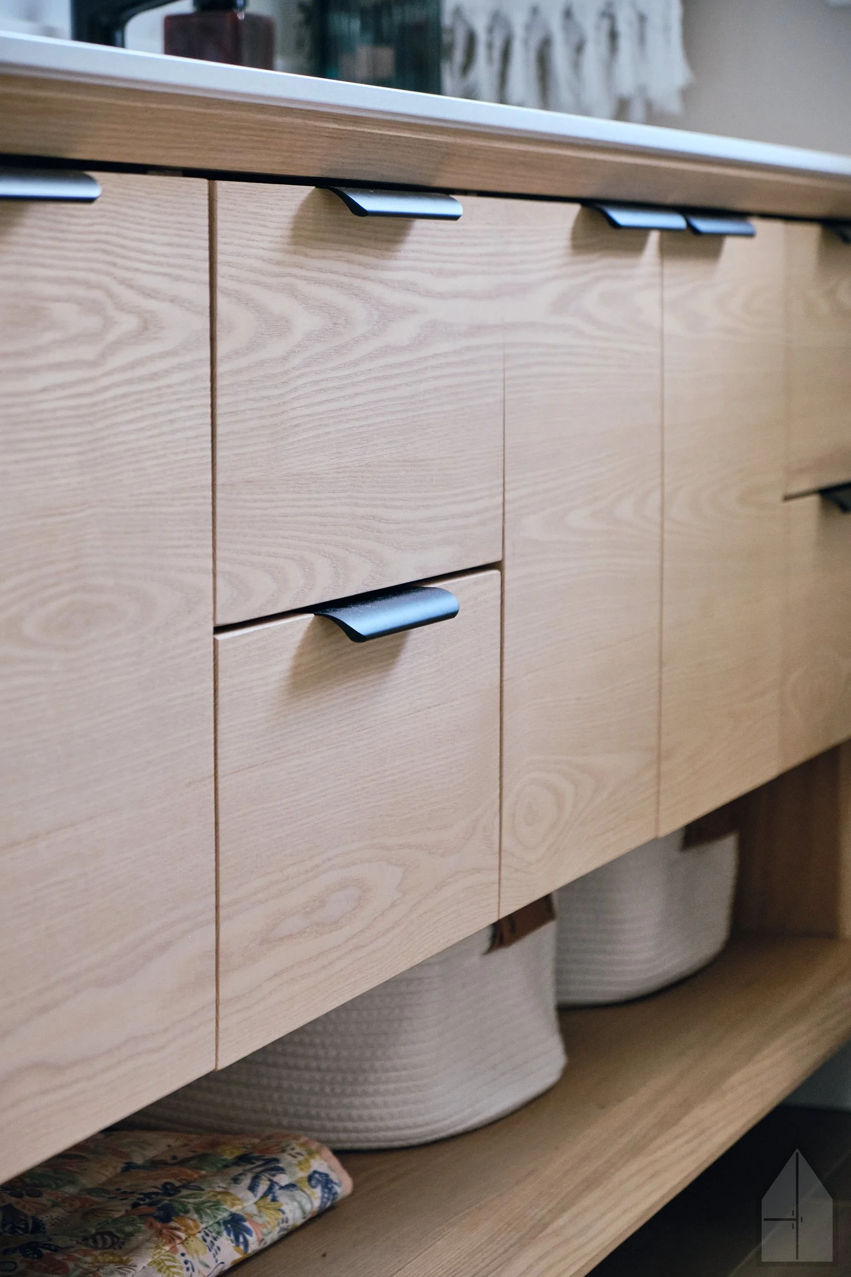 Wooden bathroom vanity with open storage underneath.