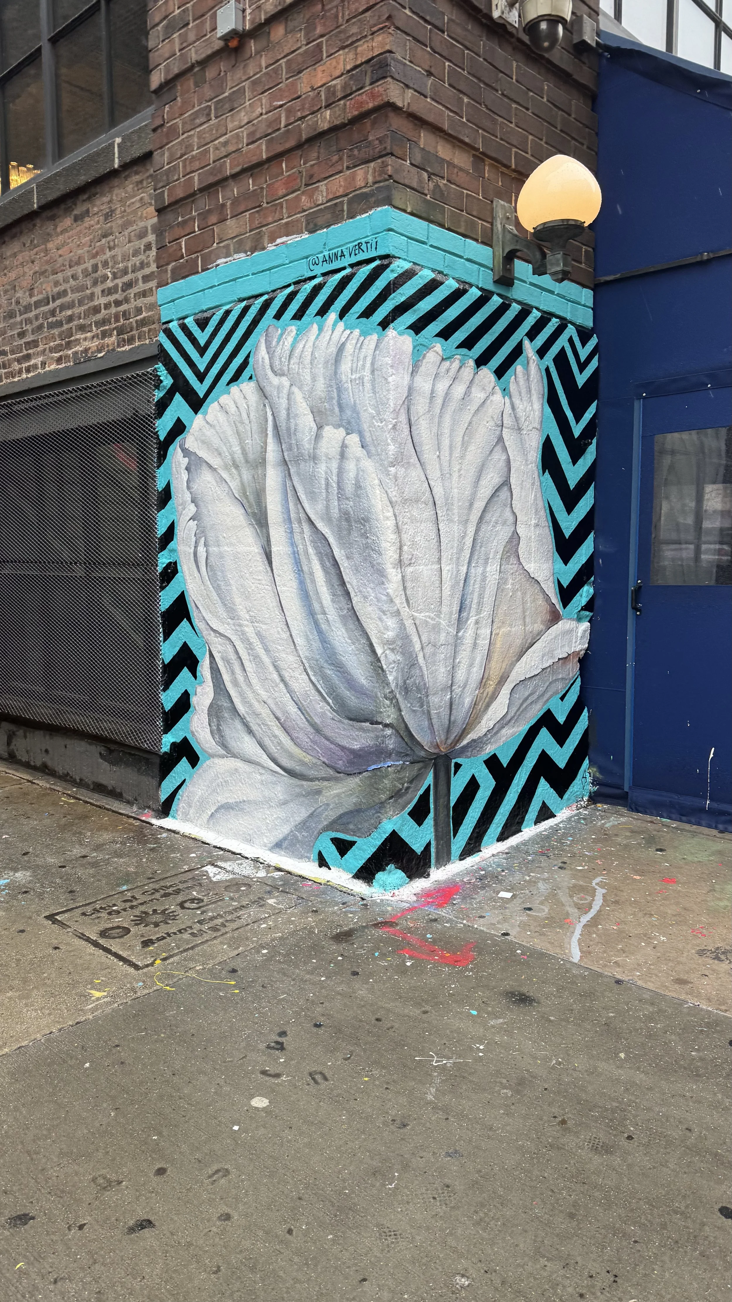 AnnaV mural at Soho House Chicago — the white flower mural seen from the adjacent wall, with the teal chevron background continuing across the corner