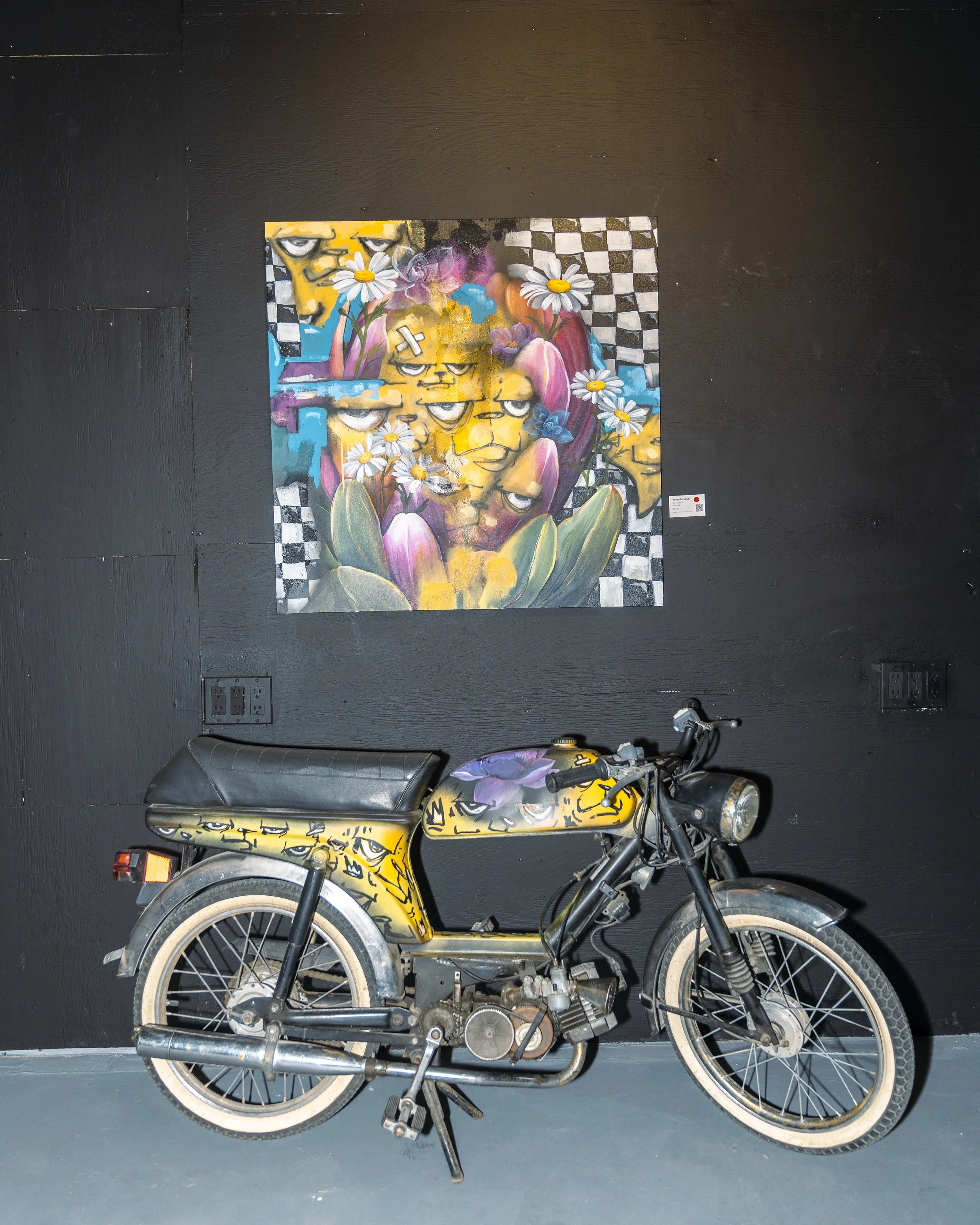 Collaboration installation — painted vintage motorcycle and wall painting at AnnaV and JC Rivera's Common Ground show, florals merged with character graffiti, Lumina Gallery Chicago 2025
