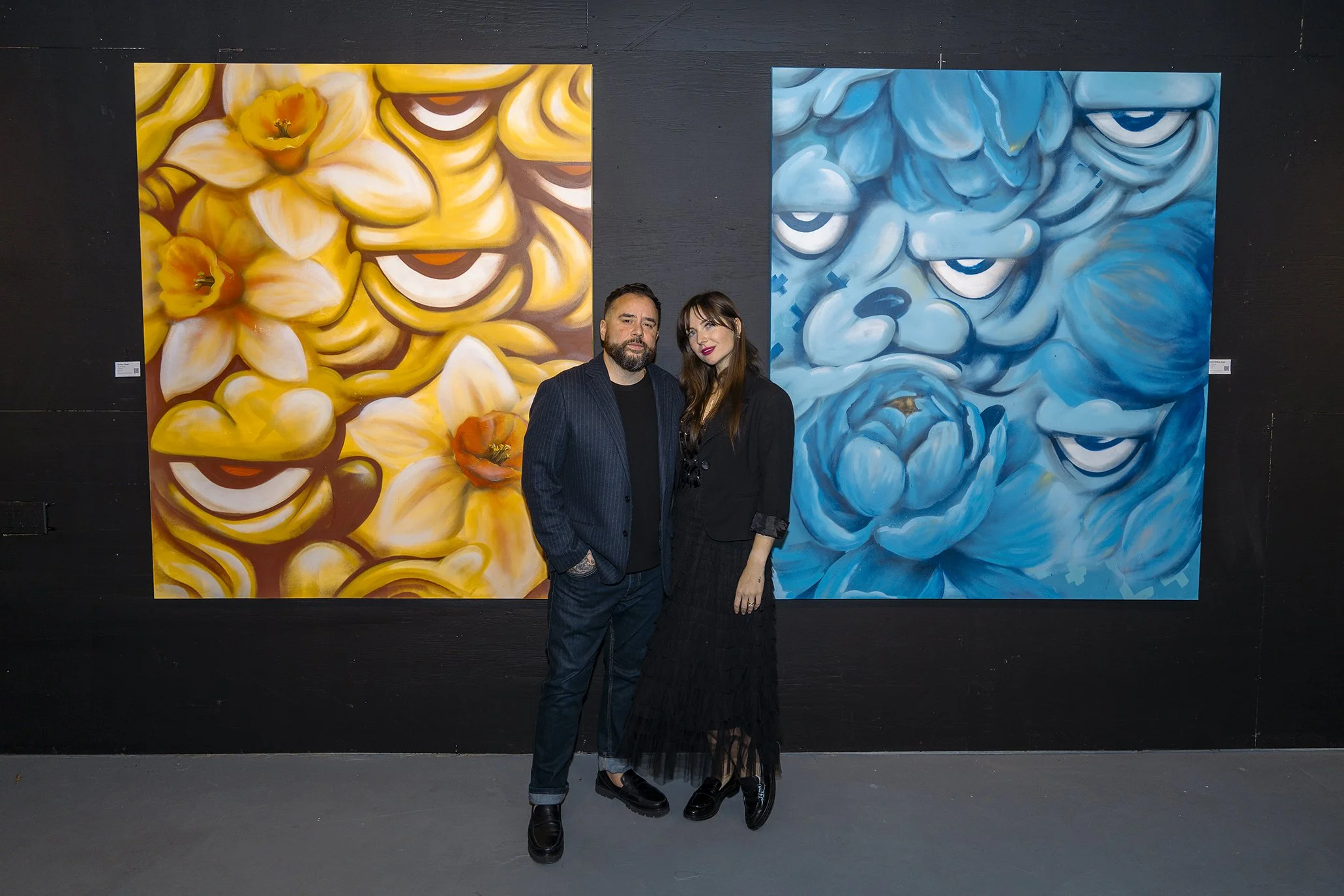 Two artists, two paintings — AnnaV's golden floral piece beside JC Rivera's blue character work at their two-person show Common Ground, Lumina Gallery Chicago 2025