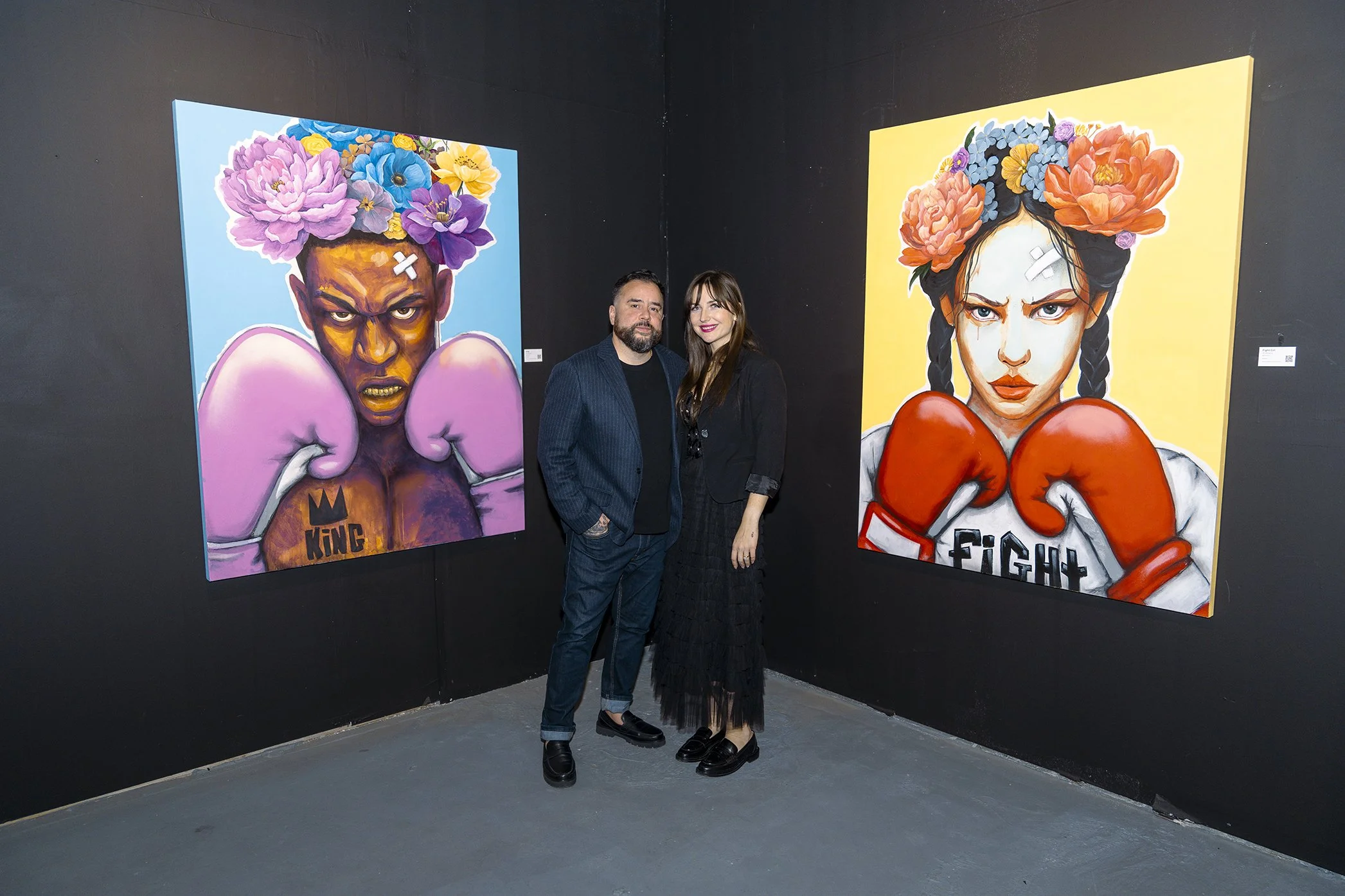 AnnaV and JC Rivera collaboration paintings — male and female boxers with flower-crowned heads, pink and red gloves, at Common Ground exhibition Lumina Gallery Chicago