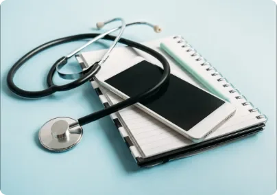 stethoscope and mobile phone on a notepad on a desk