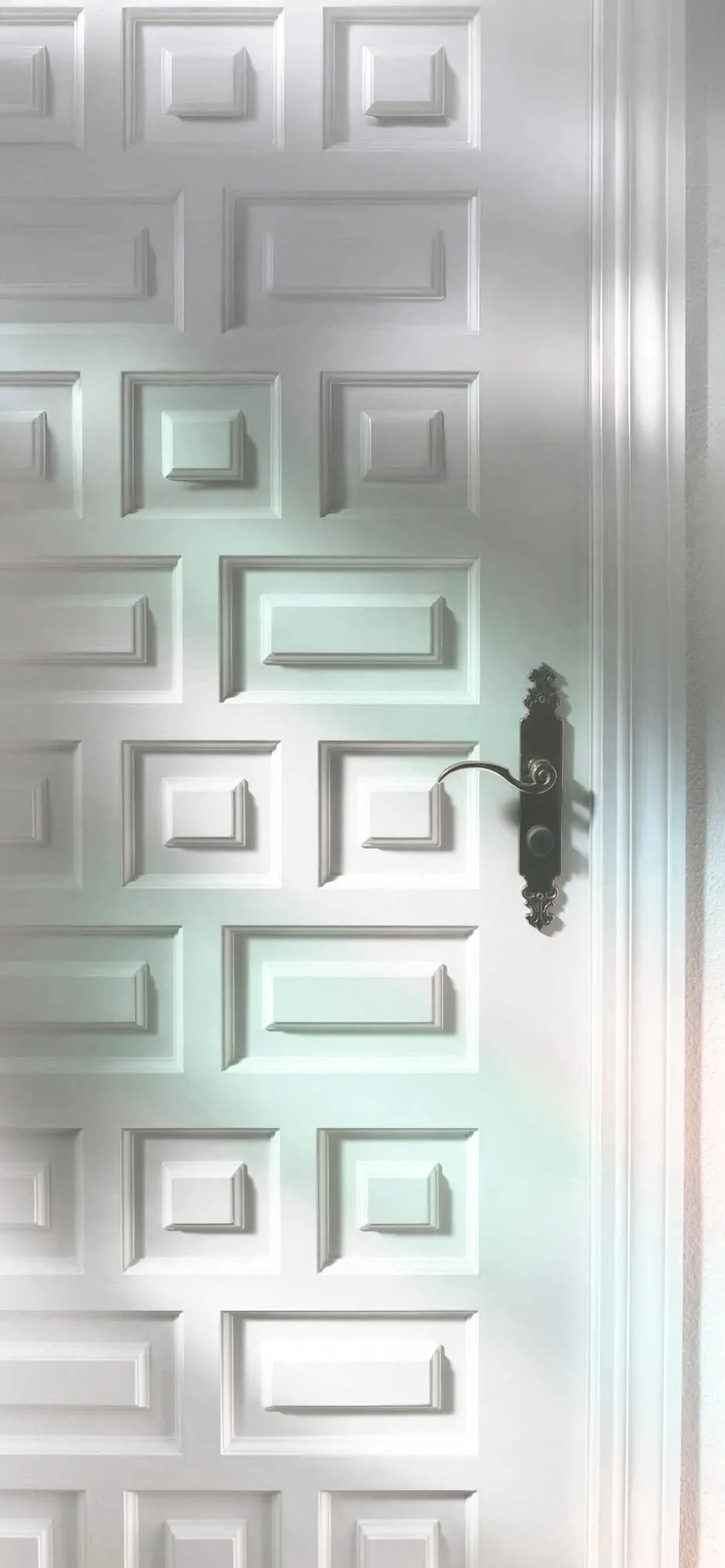 A white paneled door with a black ornate handle and a keyhole, featuring square and rectangular decorative raised panels.