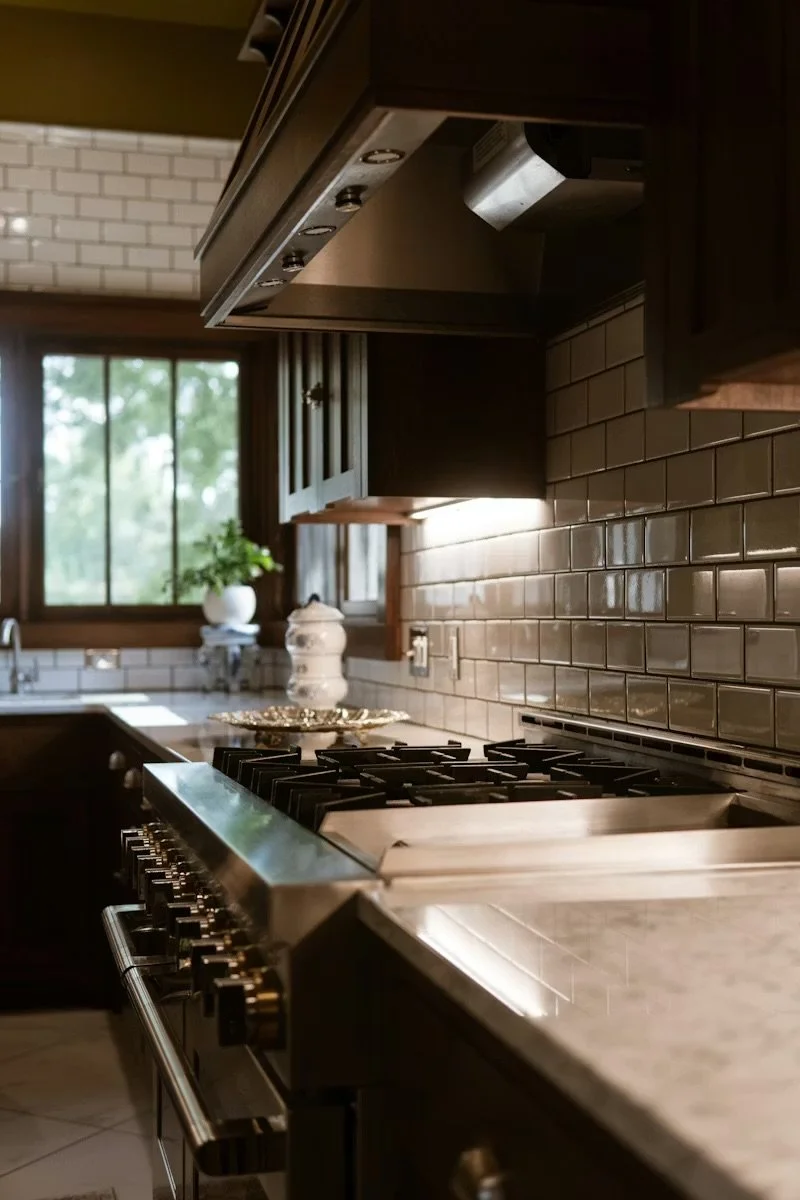 Dark brown cabinetry in country-styled newly renovated kitchen subway backsplash and marble countertops