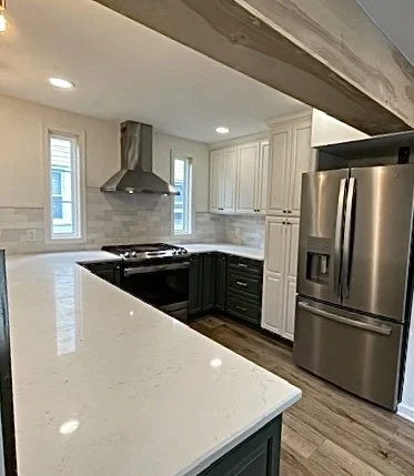 Willow Grove, PA kitchen remodel with white upper cabinets, deep green lower cabinets, quartz countertops, stainless steel appliances, and subway tile backsplash.