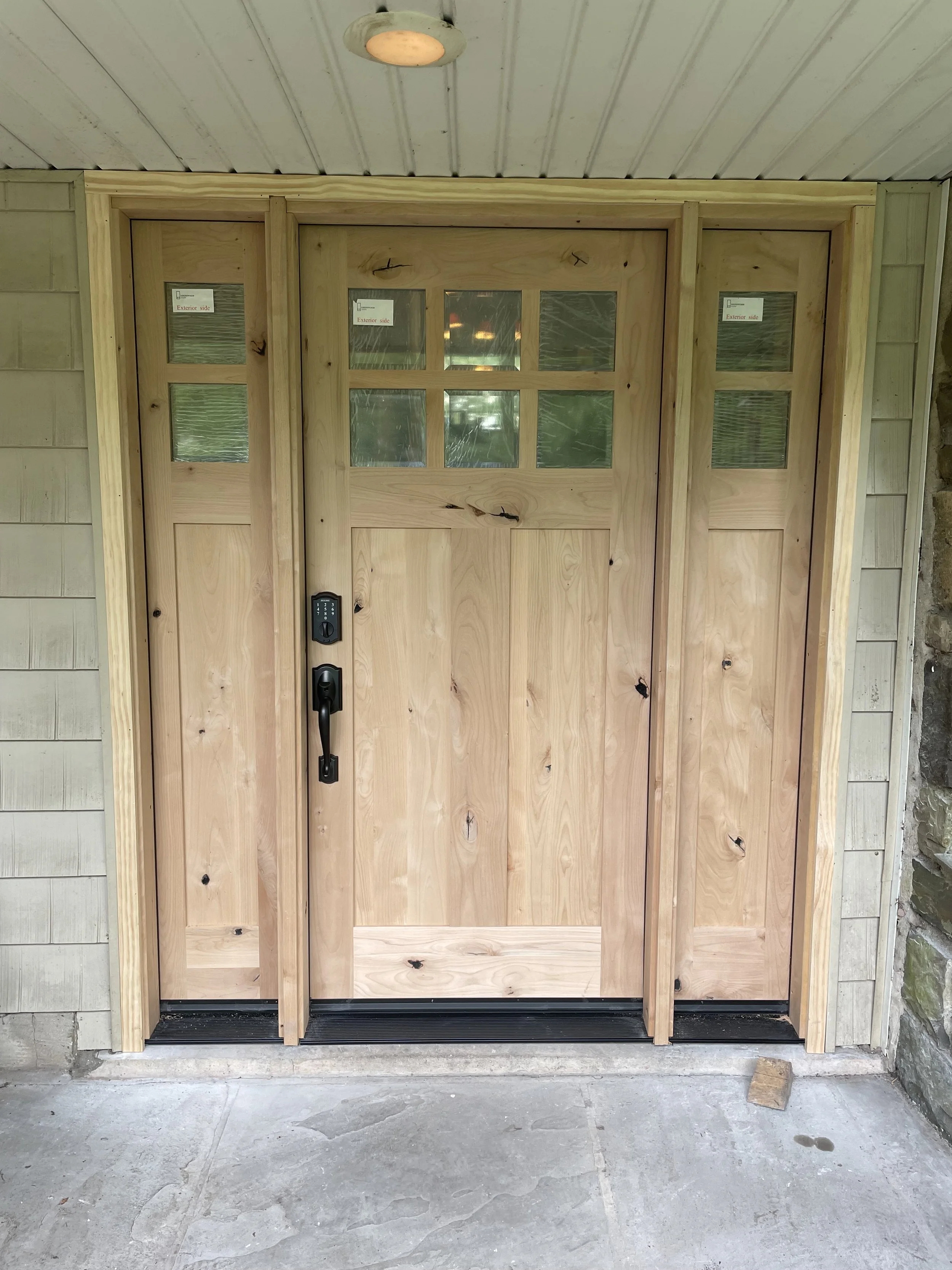 New craftsman-style knotty. Wood front door installation in Warrington, PA with glass panel sidelights and electronic keypad lock