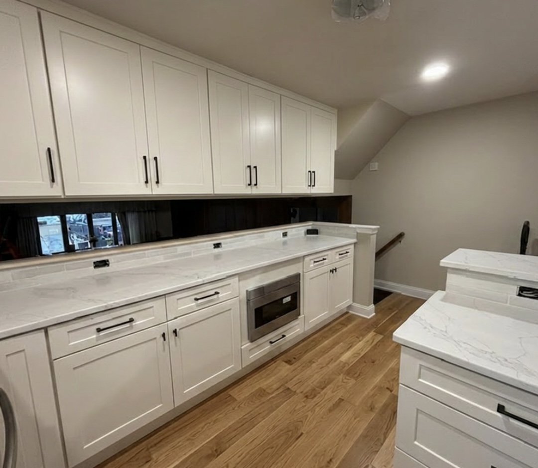 Custom white cabinetry with built-in microwave drawer and black hardware in a Perkasie kitchen remodel.
