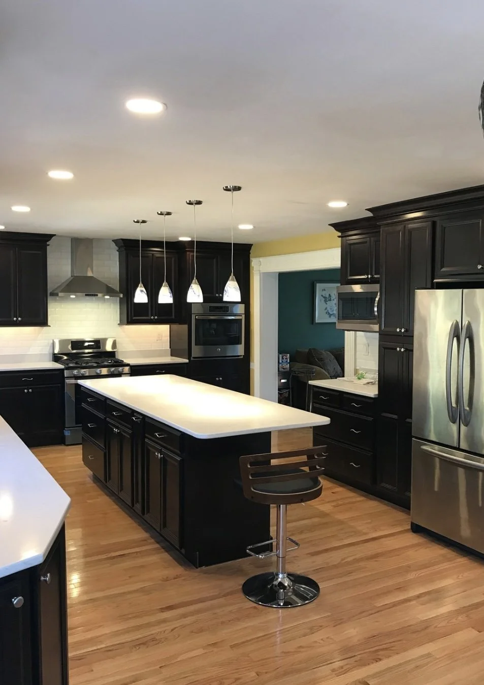 Espresso black cabinetry with larger waterfall island and stainless steel appliances on Warrington, PA kitchen remodel
