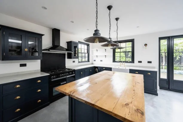 Black modern kitchen cabinets black appliances quartz countertops and wooden cutting board island countertop