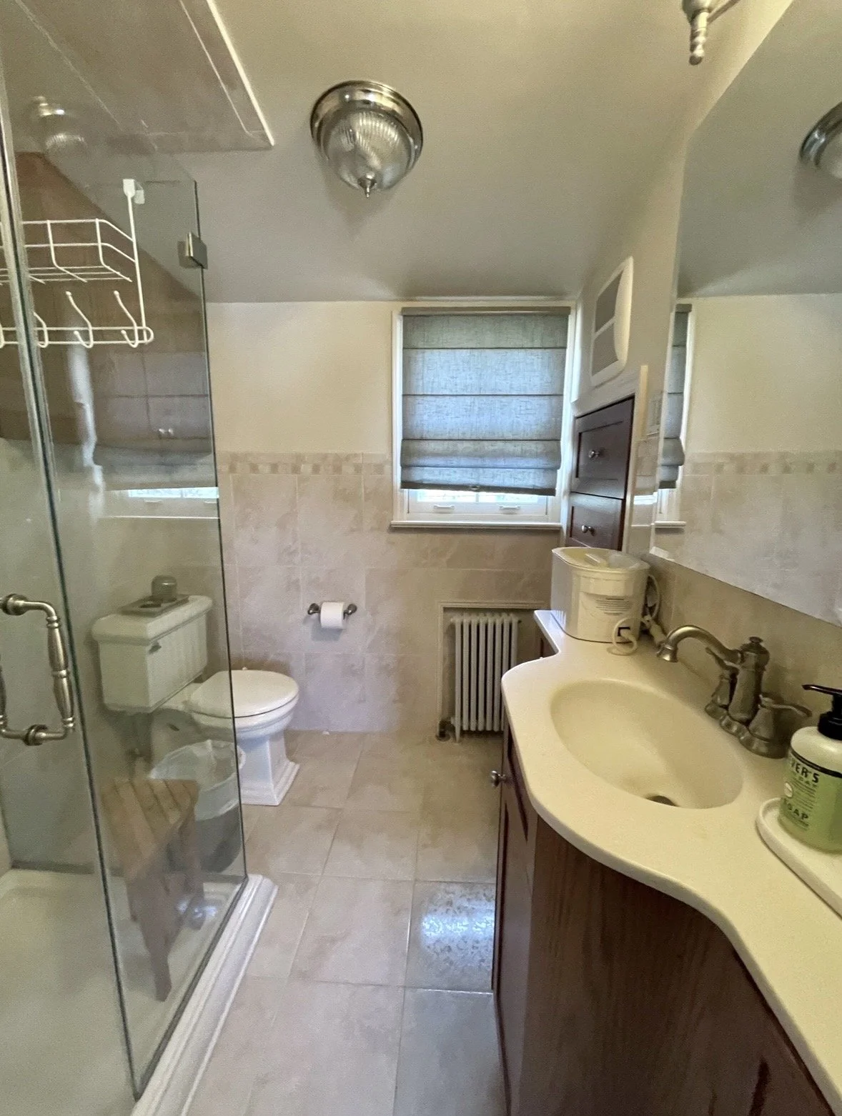 Bathroom in Upper Moreland, PA before remodeling with the original shower, vanity, toilet, and window layout.