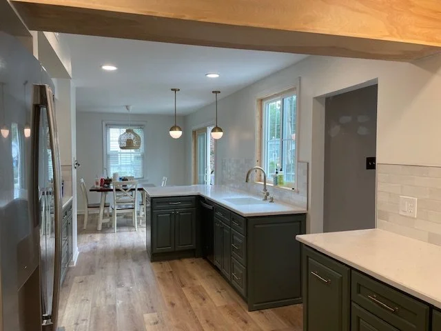 Expanded Willow Grove, PA kitchen layout with added counter space, two-toned cabinetry, pendant lighting, and an open connection to the adjoining room.