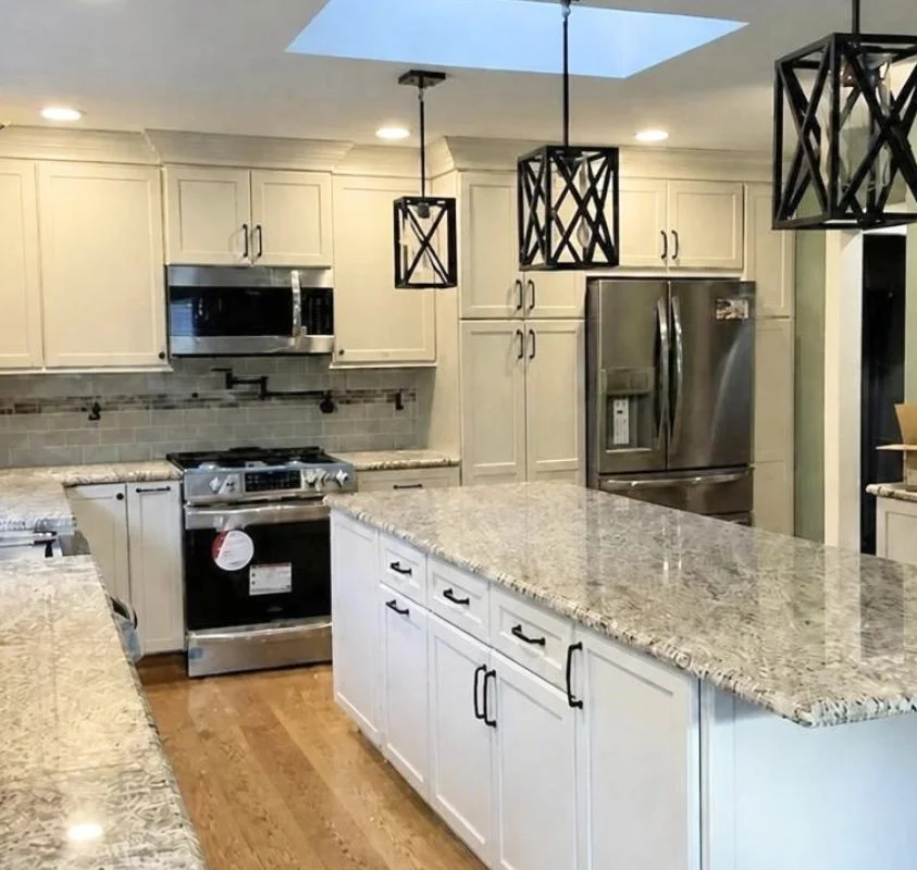 White shaker cabinet kitchen remodel with granite island countertops, stainless steel appliances, and black pendant lighting fixtures in Horsham, PA