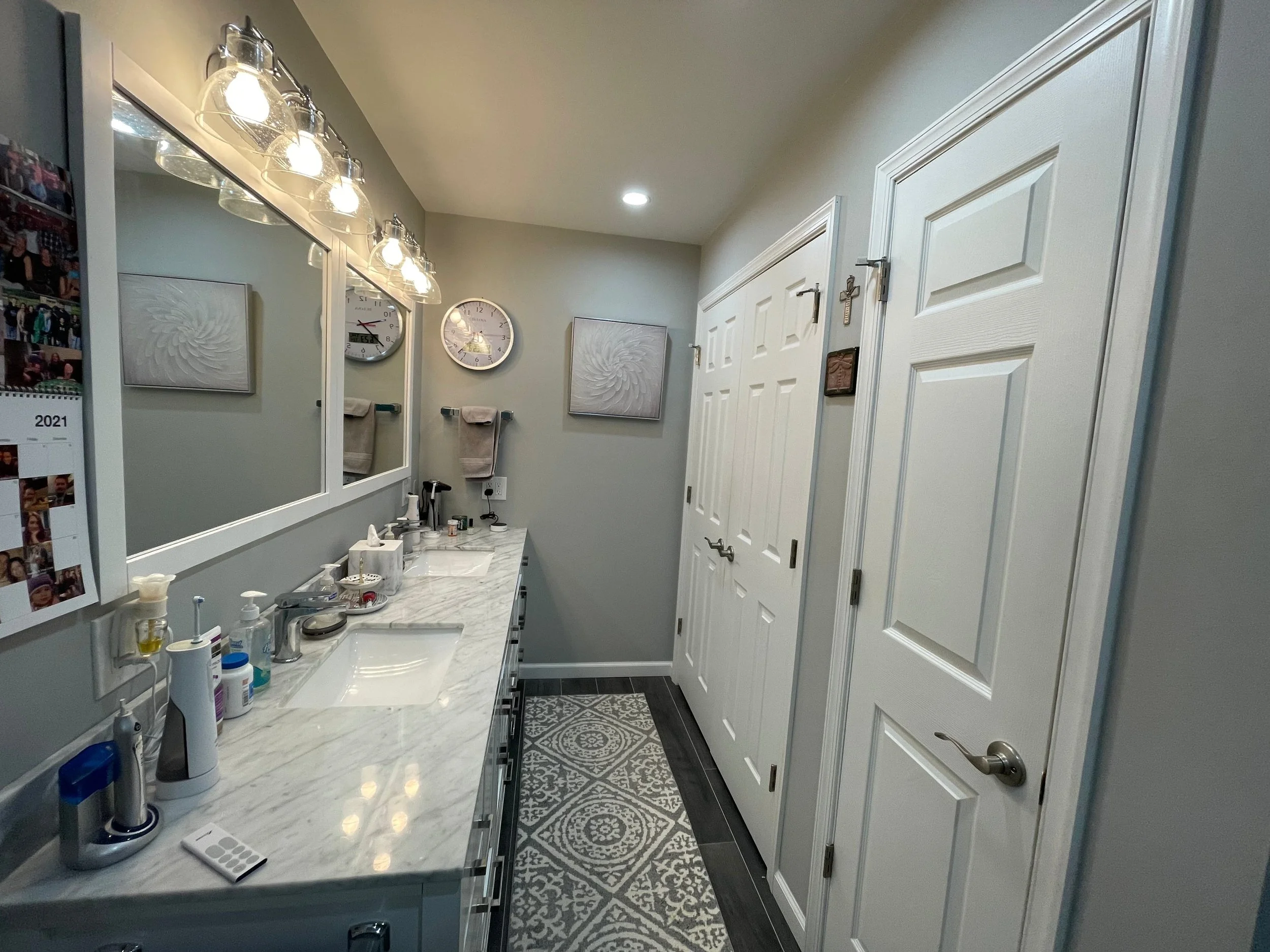 Wide view of white double vanity with marble-look countertop, chrome fixtures, vanity lighting in Hatboro, PA bathroom remodel by JWD Contractors