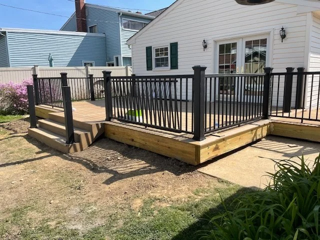 Willow Grove, PA deck build in the final stages of construction with composite decking, broad steps, and dark railing in place.