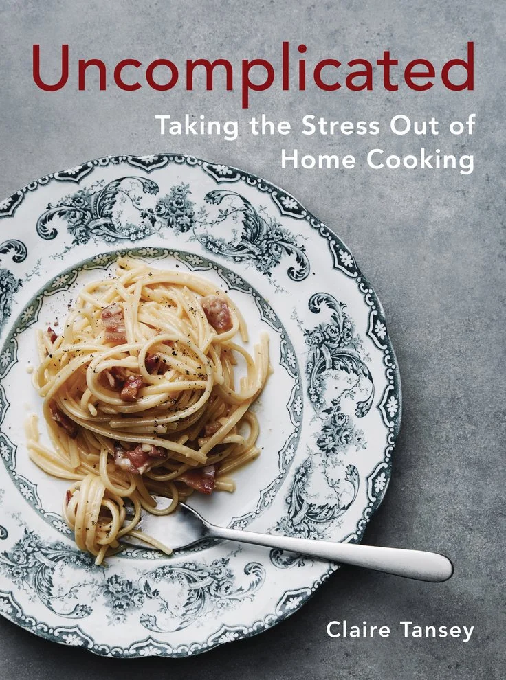 Book cover titled 'Uncomplicated: Taking the Stress Out of Home Cooking' by Claire Tansey, featuring a serving of spaghetti carbonara on a decorative plate with a fork.