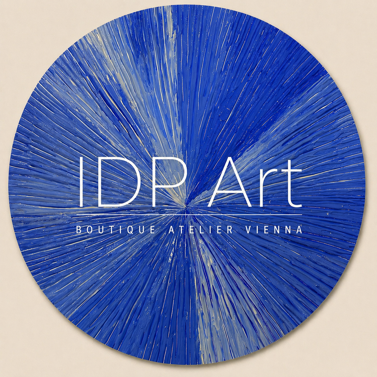 Kreisförmiges Kunstwerk bzw. Logo mit blauer Abstraktgestaltung und weißen Akzenten, mit weißem Text: IDP Art Boutique Atelier Wien.
