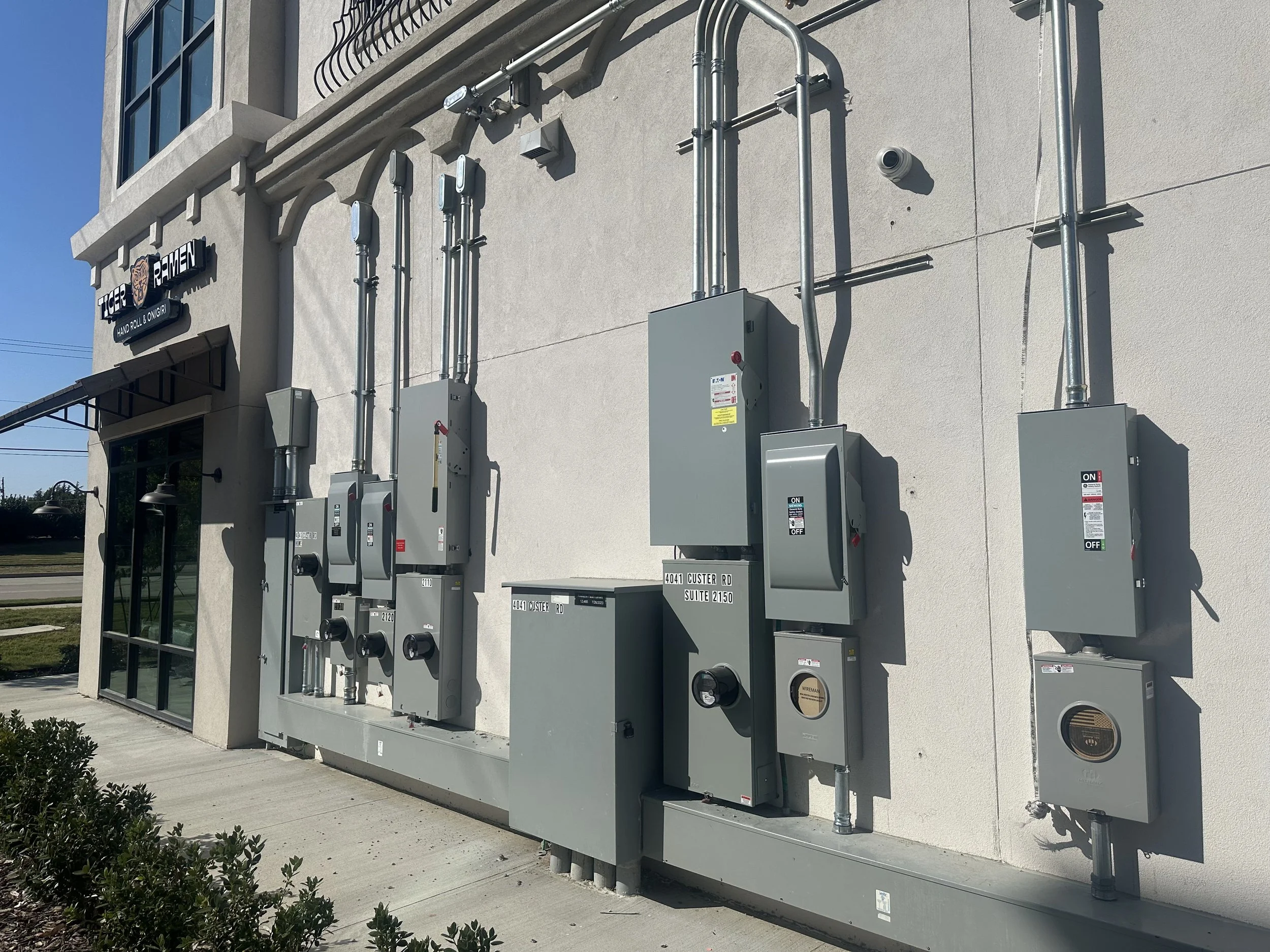 Commercial electrical installation in Dallas–Fort Worth featuring multi-meter panels, disconnects, and conduit work by licensed electrician