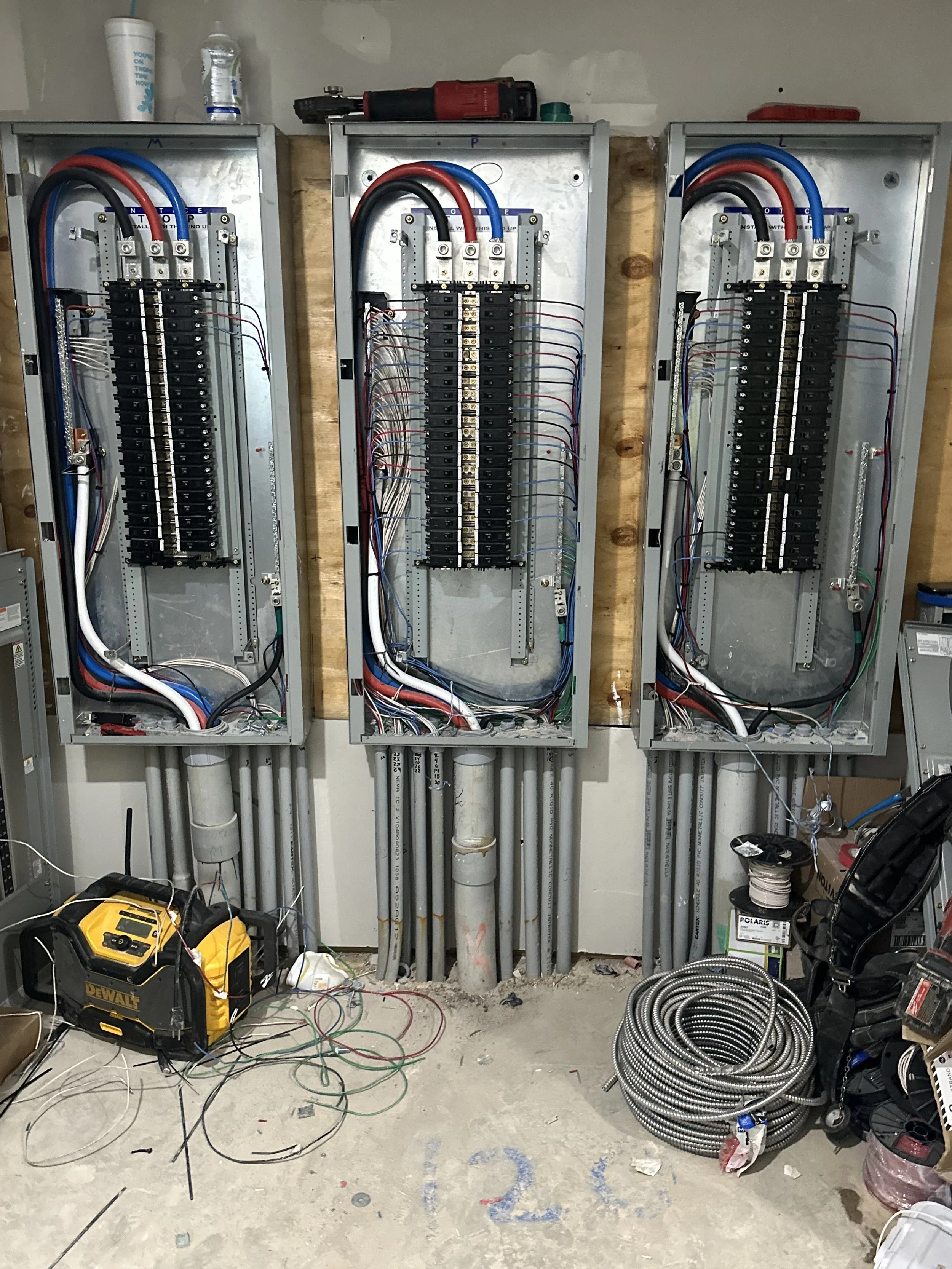 Commercial electrical panel installation in Dallas–Fort Worth with multiple breaker panels, organized wiring, and conduit runs by licensed electrician